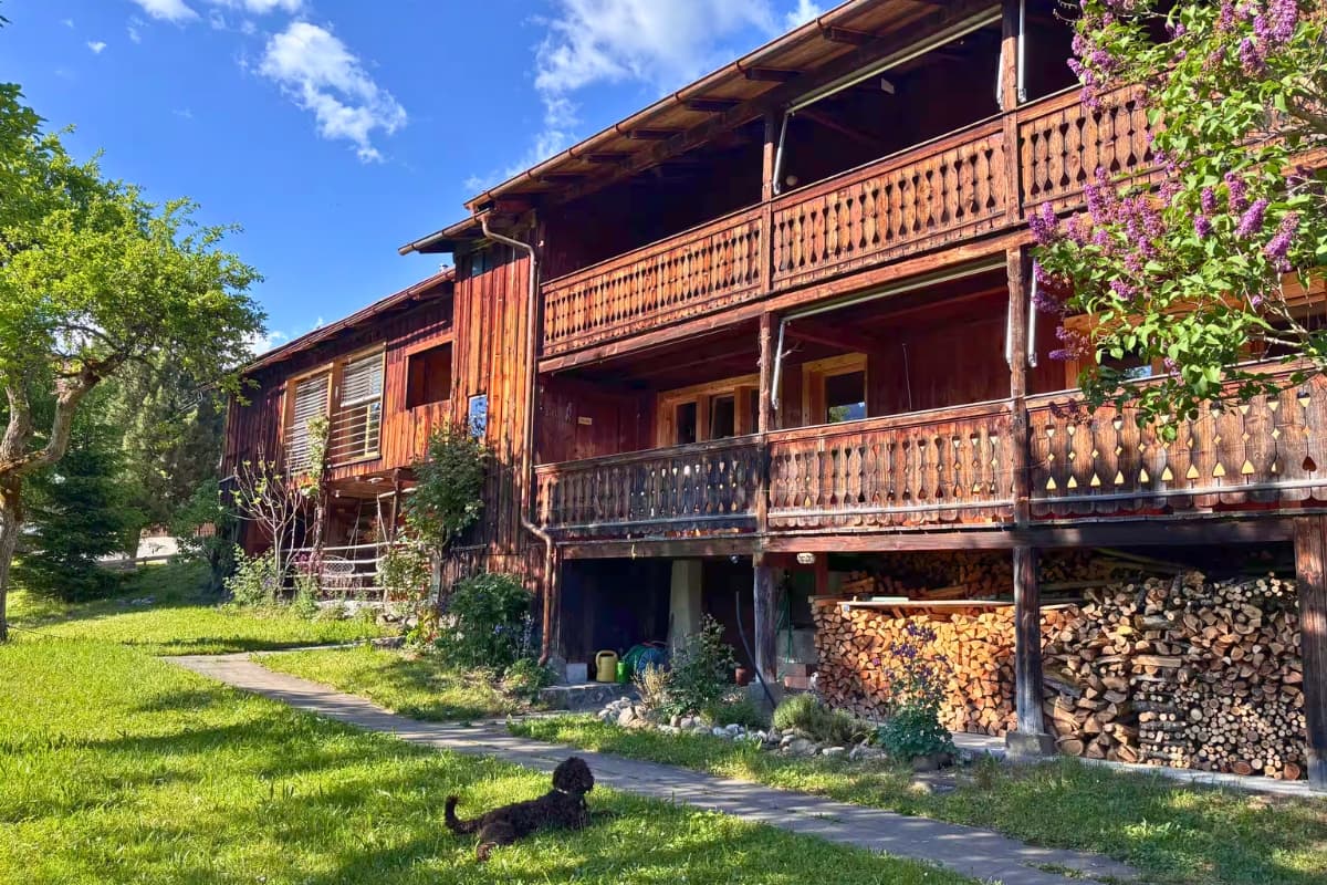 Chalet exterior with dog and lilac tree